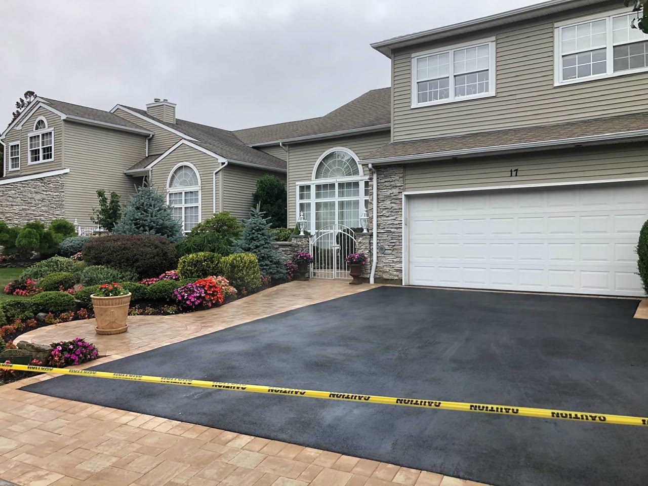 Sealed blacktop driveway with paver border on a colonial